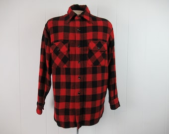 May include: A red and black plaid flannel shirt with long sleeves and button closure. The shirt has two chest pockets with button closures.