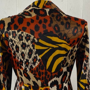 Puede incluir: Una bata de manga larga con cuello, con un dise&ntilde;o estampado en marr&oacute;n, negro, amarillo y blanco.