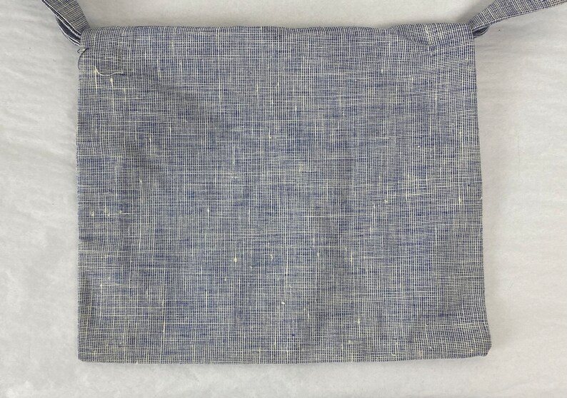 May include: A small blue and white checkered fabric bag with a strap.