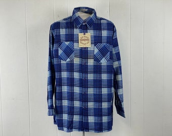 Può includere: Una camicia a maniche lunghe a quadri blu e bianchi con colletto abbottonato e due tasche sul petto. La camicia ha un'etichetta che recita "Old South" e "Guaranteed Products".