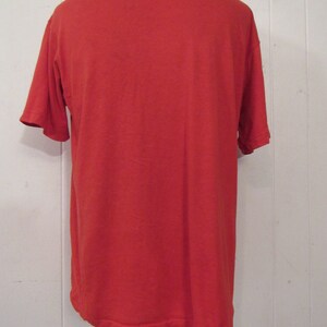 Puede incluir: Una camiseta roja lisa de manga corta.