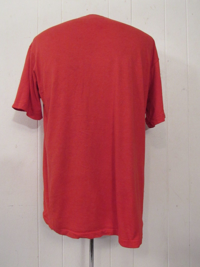 Puede incluir: Una camiseta roja lisa de manga corta.