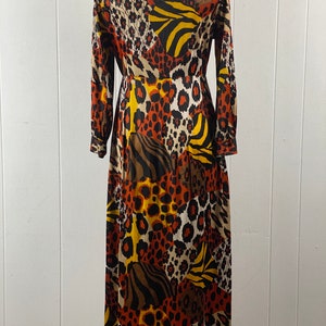 Puede incluir: Un vestido largo de manga larga con un dise&ntilde;o de patchwork que presenta varios estampados de animales en tonos marrones, naranjas, amarillos y negros.