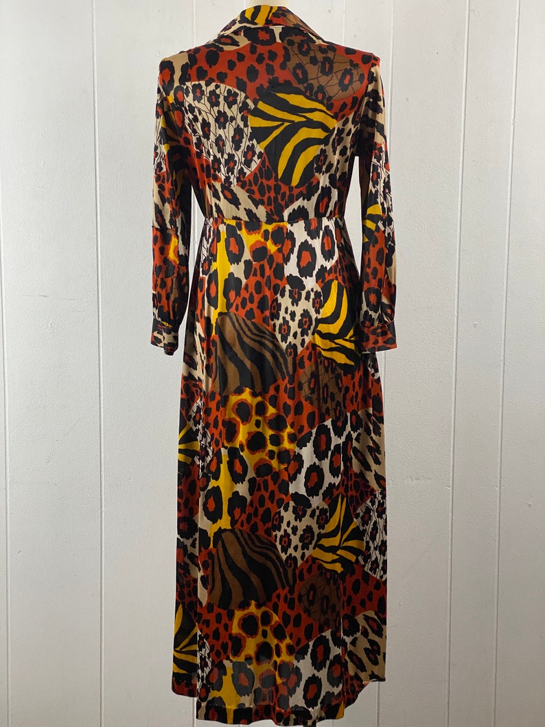 Puede incluir: Un vestido largo de manga larga con un dise&ntilde;o de patchwork que presenta varios estampados de animales en tonos marrones, naranjas, amarillos y negros.