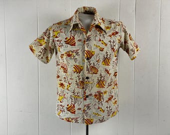 May include: A short-sleeved button-down shirt with a white background and a colorful print of fish and coral. The shirt has a collar and a button-up front.