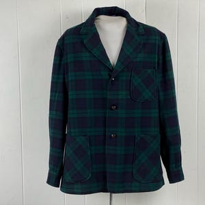 May include: A green and navy plaid jacket with a notched collar, two front pockets, and three buttons. The jacket has a classic, tailored design and is made of a thick, woven fabric. The jacket is a size medium.