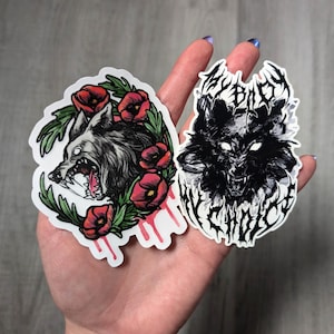 May include: Two wolf stickers, one with a black and white wolf with the text "My Blood My Choice" and the other with a wolf with red flowers and dripping blood.