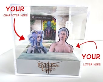 May include: A clear acrylic display case with two character cutouts and a backdrop depicting a stained-glass window. The base of the case displays the text "Baldur's Gate 3". The text "Astarion approves" is also visible.