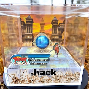 Op de afbeelding: Een heldere acryl display case met een miniatuur videogame diorama. De scène toont een personage met een zwaard, een blauw portaal en het woord "hack". De case staat op een zwarte basis.