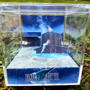May include: A Final Fantasy VII diorama in a clear acrylic box. The scene depicts characters against a starry night sky with the text "Cloud: All right...I promise." The base features the game's logo.
