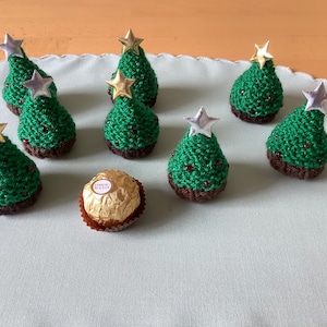 Hand knitted Christmas trees with a gold or silver star. Made to cover a Ferrero Rocher chocolate.