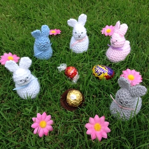 An Easter bunny PDF knitting pattern in two sizes. The smaller rabbit covers a Cadbury&#39;s creme egg. The larger rabbit covers a Kinder egg.