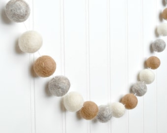 Guirnalda de bolas de fieltro neutras: beige, avena y marfil para decoración infantil.