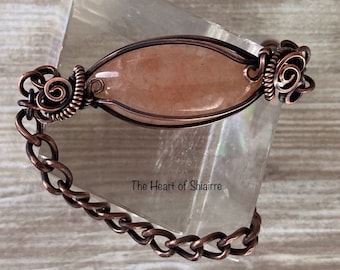 Bracciale in avventurina arancione avvolto in filo metallico. Gioielli artigianali in rame.