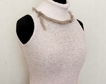 Ein einzigartiger Rollkragenpullover, eine Weste mit Besatz, ein warmer Rollkragenpullover in einer hellen Farbe mit Besatz. Weste mit Besatz.