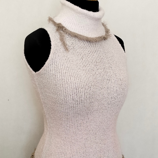 A unique turtleneck, a trimmed vest, a warm turtleneck in a light color with trim. Vest with trim.