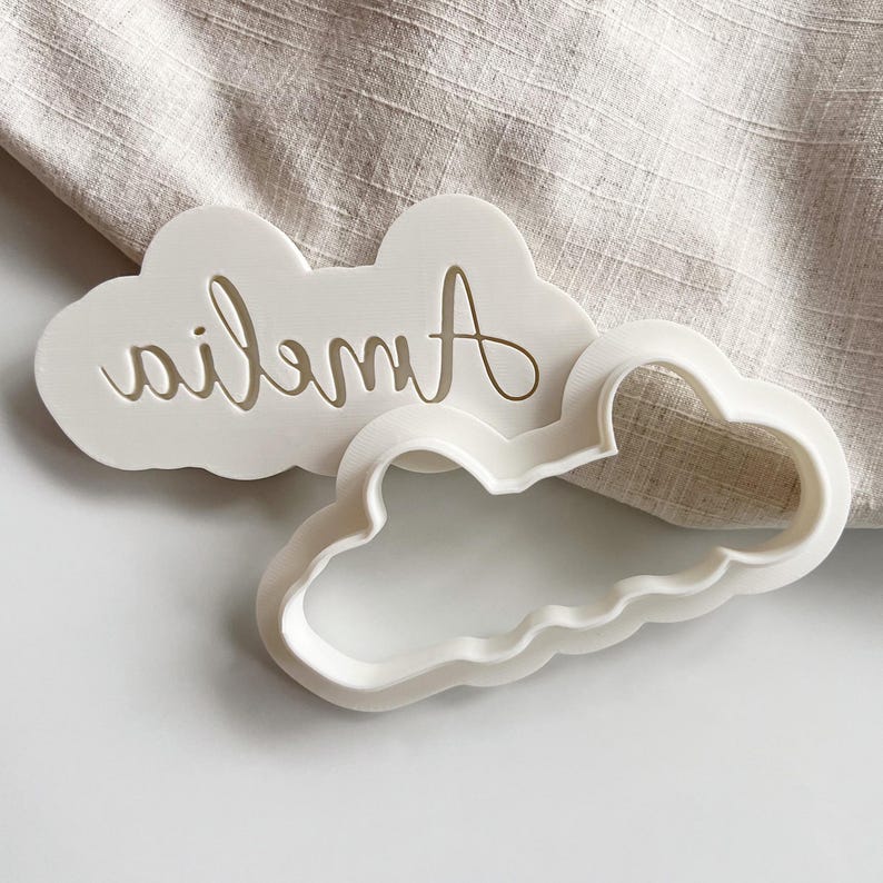 Plastic cookie cutter and fondant stamp with a custom design of a name in script font, made of durable plastic and shown on a white countertop.