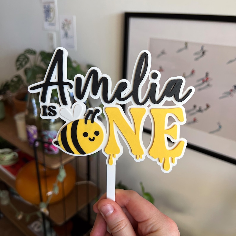Custom name bee 1st birthday cake topper for girl with floral and honeybee details, perfect for sweet as can bee party theme