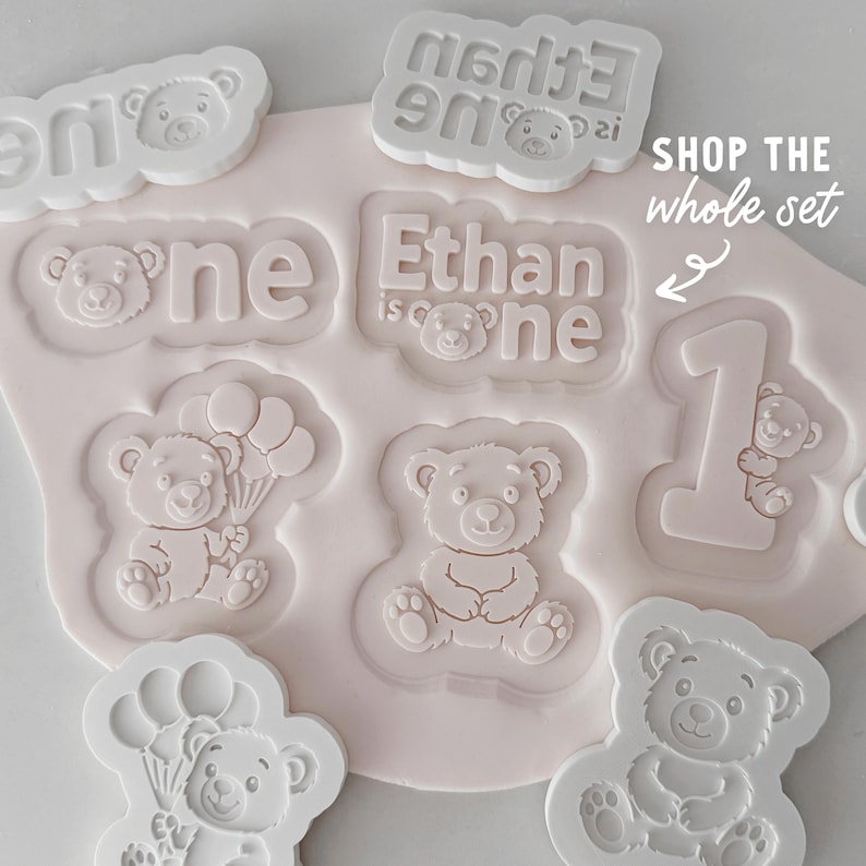 Bear cookie cutter and fondant stamp. Shown on a flat surface.
