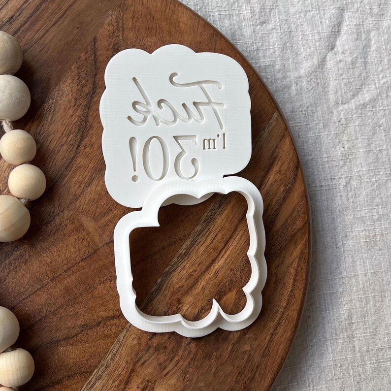 Plastic cookie cutter and fondant stamp with a custom design saying 'Fuck I'm 30!', made of durable plastic and shown on a countertop.