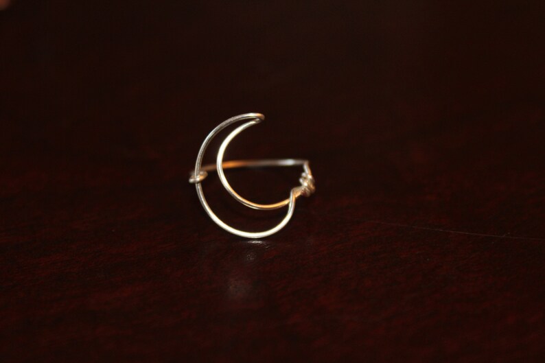 Op de afbeelding: Een zilveren halve maan ring met een dubbeldraads ontwerp.