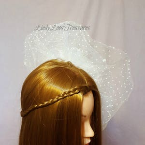 Op de afbeelding: Witte bruids sluier met stippen, gedragen door een mannequin met lang bruin haar dat in een vlecht is gevlochten.
