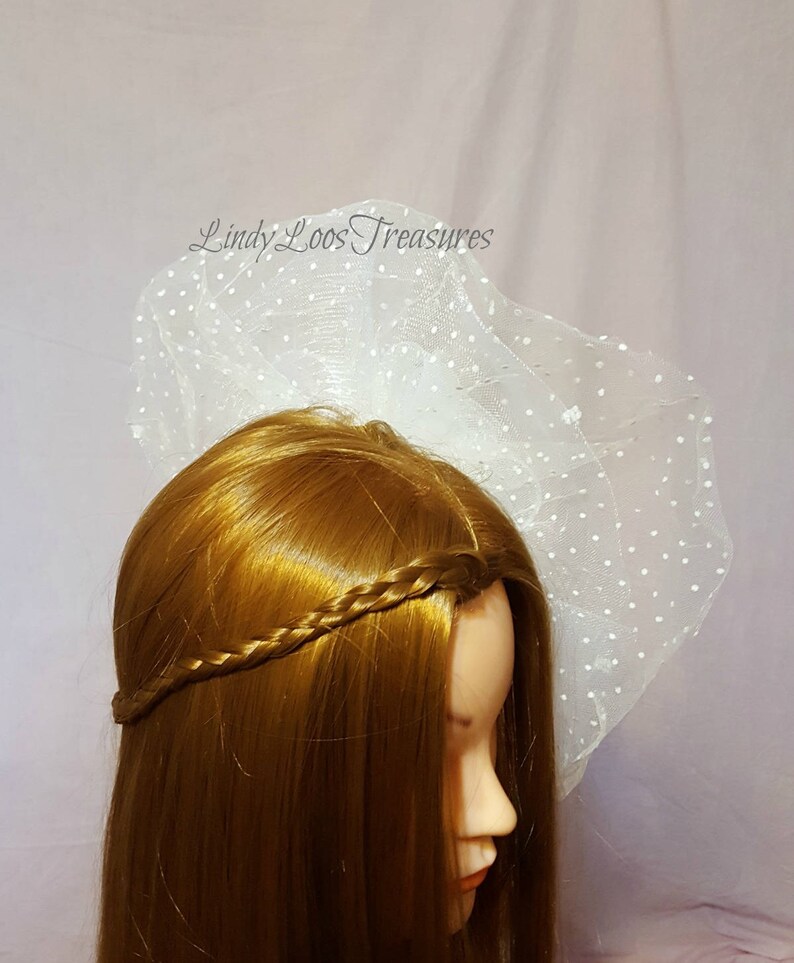 Op de afbeelding: Witte bruids sluier met stippen, gedragen door een mannequin met lang bruin haar dat in een vlecht is gevlochten.