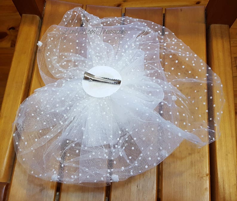 Op de afbeelding: Witte tule haarspeld met witte stippen. De speld is bevestigd aan een witte cirkel.