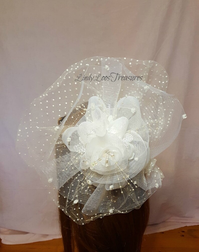 Op de afbeelding: Witte tule haar kam met een grote witte bloem en kleine witte stippen. De kam is gelabeld "Lindy Loos Treasures".