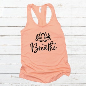 May include: Peach-colored tank top with a black lotus flower graphic and the word "Breathe" in a cursive font.