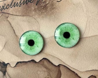 Puede incluir: Dos ojos de vidrio verde con pupilas negras. Los ojos son redondos y tienen un iris blanco con venas verdes.