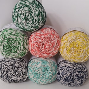May include: Six balls of yarn in various colors, including green, red, yellow, blue, and turquoise, with white stripes. The yarn is arranged in a pyramid shape.