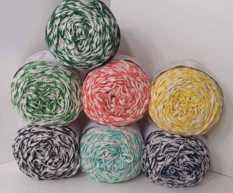May include: Six balls of yarn in various colors, including green, red, yellow, blue, and turquoise, with white stripes. The yarn is arranged in a pyramid shape.