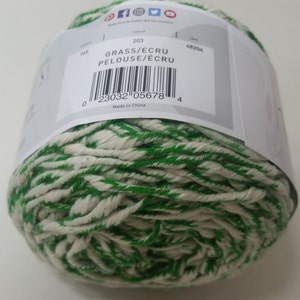 May include: A ball of green and white yarn with the label "GRASS/ECRU PELOUSE/&Eacute;CRU" and the color number 203. The label also includes a barcode and the text "Made in China".