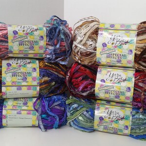 May include: Eight skeins of yarn in various colors, including pink, blue, gold, red, purple, and green. Each skein has a label that reads "Yarn & Bee" and "Special Effects".