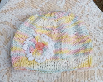 Knitted Baby Girl Hat with a Crocheted Flower in Pastel Pink, Yellow, Blue, and White