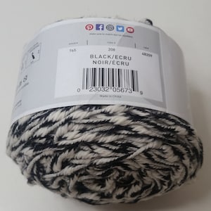 May include: A ball of black and ecru yarn with a label that reads "Black/Ecru Noir/Ecru" and has a barcode and the number 208. The label also says "Made in China".