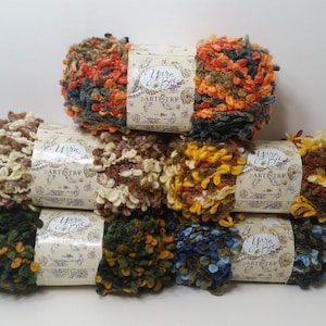 May include: Eight skeins of yarn in various fall colors, including orange, brown, yellow, green, and blue. The yarn is a fluffy, textured type and is labeled "Yarn & Bee Artistry".