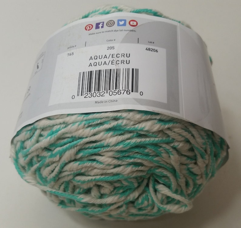 May include: A ball of aqua and ecru yarn with a white label that says "Aqua/Ecru" and has a barcode. The label also says "Color # 205" and "Lot # 48206". Made in China.