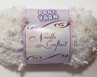 May include: A white and pink ball of "POOF YARN" by Needle Crafters. The yarn is fluffy and has a sparkly texture.