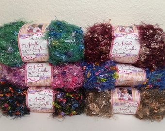 May include: Eight skeins of multi-colored yarn with a fuzzy texture. Each skein has a label that reads "Multi-Dyed Stranded Loops Needle Crafters 24 oz 100% Acrylic Multi-Twist".