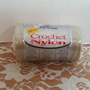 May include: A spool of white crochet nylon thread by J&P Coats. The label reads "New! Crochet Nylon" and includes information about the thread in English, French, and Spanish.