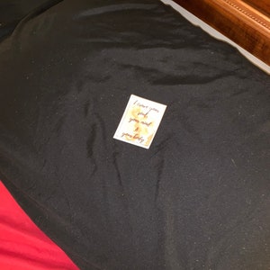Peut inclure: Une petite carte dor&eacute;e avec le texte "Je cr&eacute;e votre &acirc;me, votre esprit et votre corps" sur un oreiller noir.