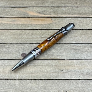Penna da scrittura realizzata a mano in pregiato legno di radica di Chittum. Elegante penna a sfera a rotazione con refill Parker, ideale per il diario. Radica di Smoketree.