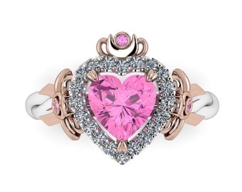 May include: A pink heart-shaped ring with a halo of small diamonds and a crown on top. The ring is made of white and rose gold.