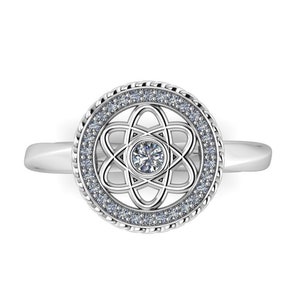 May include: A silver ring with a round atom design set with small diamonds. The center of the atom design features a larger diamond.
