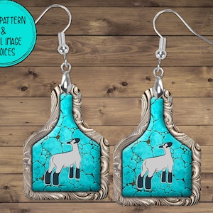 May include: A pair of silver earrings with a turquoise and silver design. The earrings are shaped like a livestock tag and feature a white lamb silhouette.