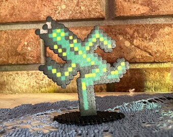 May include: A green and yellow pixelated lizard figurine on a black base. The lizard is in a jumping pose with its legs outstretched.