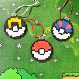 May include: Three pixel art ornaments with different designs. The first ornament is yellow and black with a white background. The second ornament is red and white with a white background. The third ornament is blue and white with a white background.
