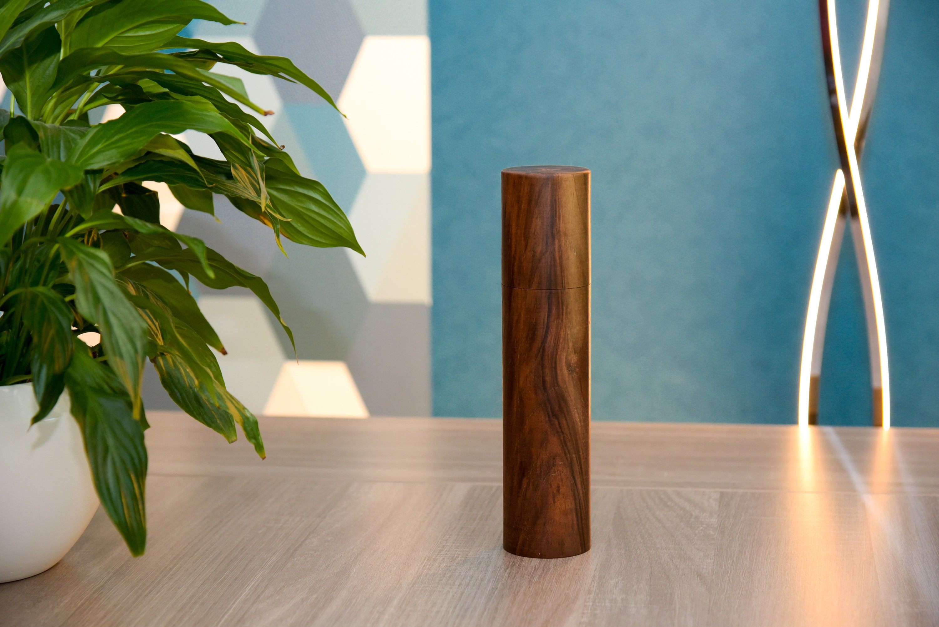 On a gray wooden surface lie spices, hand-made wooden pepper mill